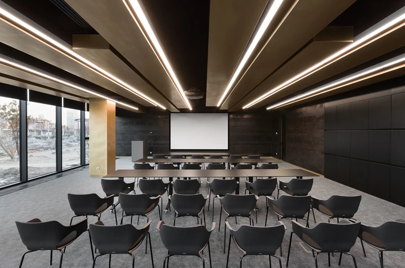 Workplace presentation room with linear lighting and flexible seating
