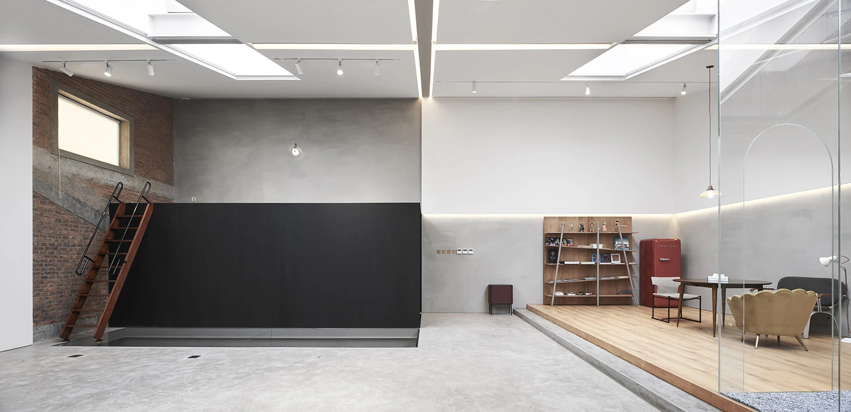 Light-filled creative workplace with a sculptural stair, exposed brick and glazed meeting space